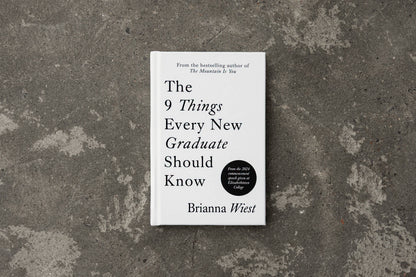 Book titled 'The 9 Things Every New Graduate Should Know' by Brianna Wiest on a textured gray surface