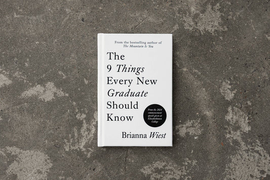 Book titled 'The 9 Things Every New Graduate Should Know' by Brianna Wiest on a textured gray surface