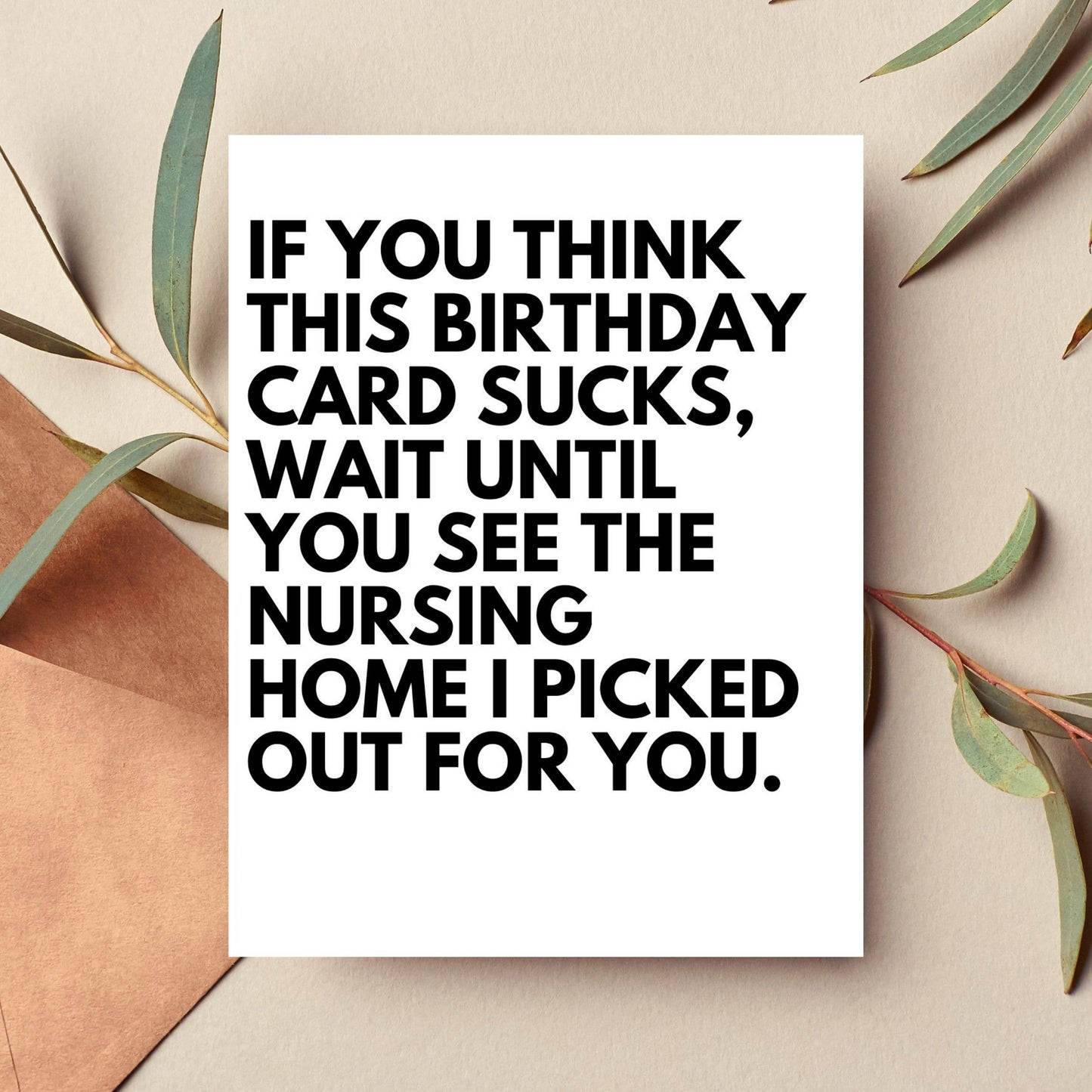 Birthday card with humorous text on a beige background with leaves