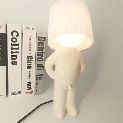 Shy little boy reading lamp