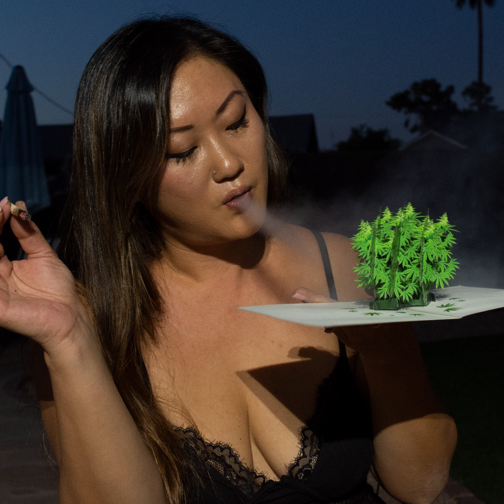 Woman holding a tray with a small green plant in an outdoor setting