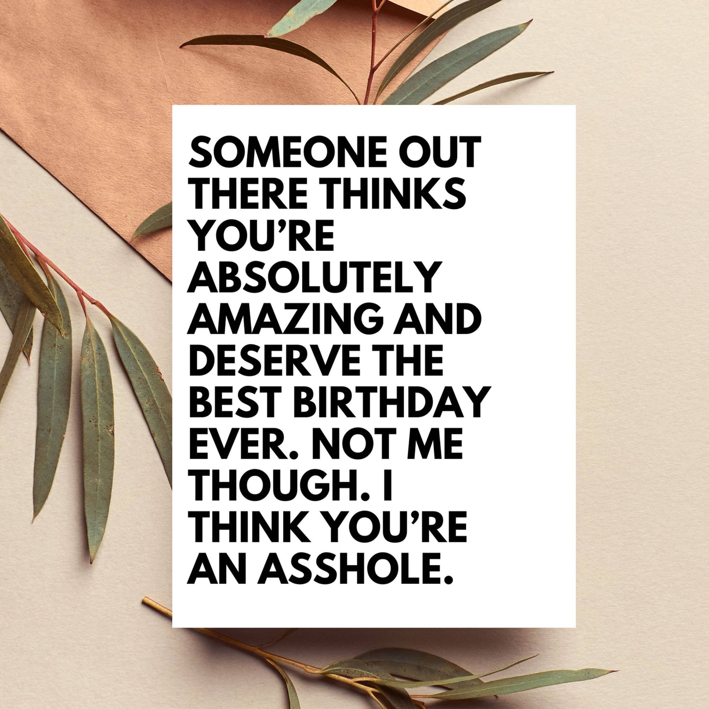 Motivational quote on a white card with leaves on a beige background