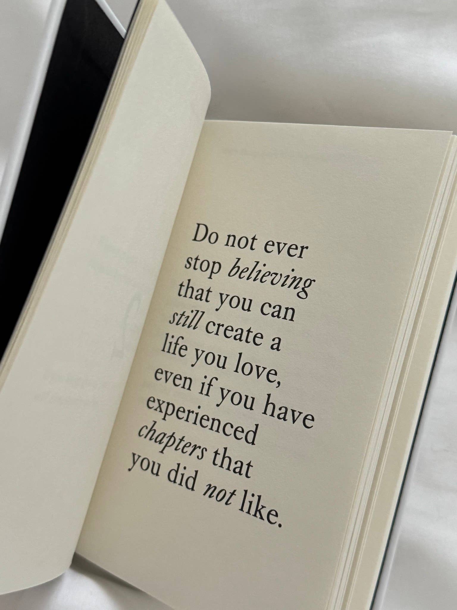 Open book with a motivational quote on a white background