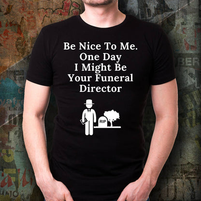 Person wearing a black t-shirt with humorous text and graphic design against a textured wall background.