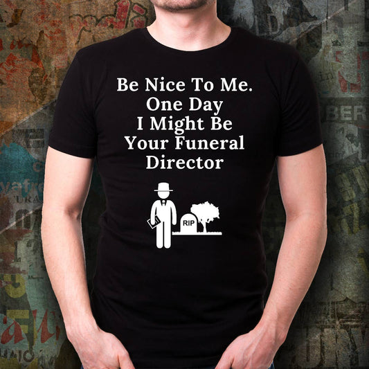Person wearing a black t-shirt with humorous text and graphic design against a textured wall background.